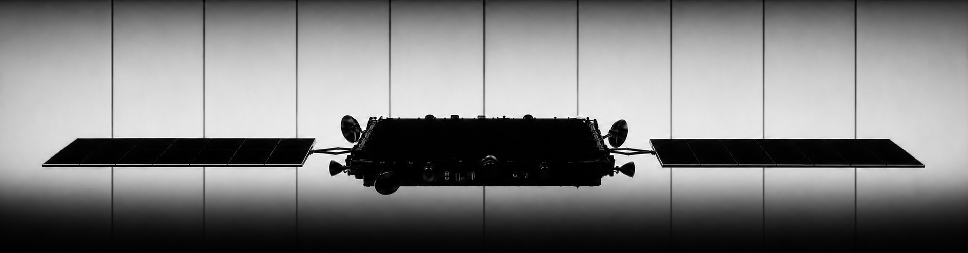 Satellite silhouette against a bright hangar backdrop
